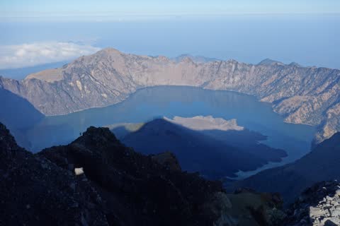 View from the summit over the whole of Segara Anak lake, the mountain's shadow falling across the Barujari cone