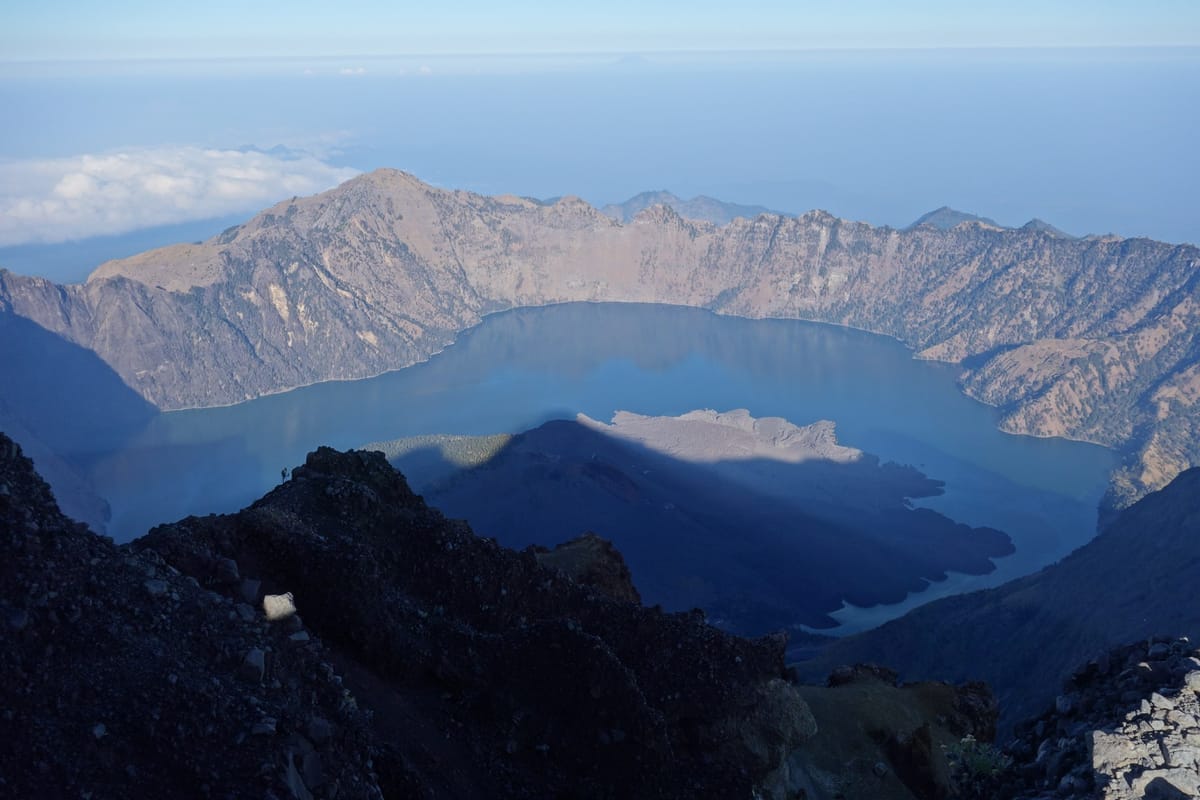 View from the summit over the whole of Segara Anak lake, the mountain's shadow falling across the Barujari cone