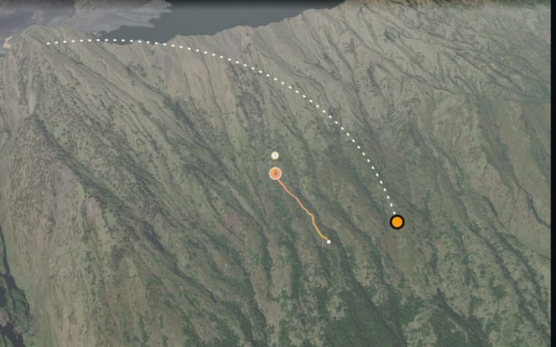 Mountainside seen from high above, a dotted line shows the camera flying towards the route