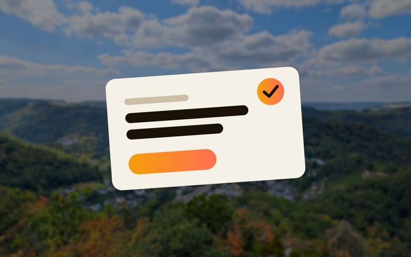 An invitation card in front of a view over a wooded valley